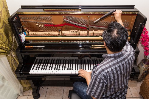 A technician tunes a piano.